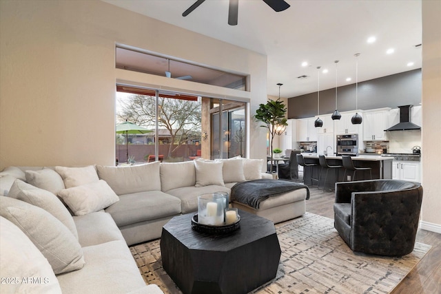 living room featuring sink, ceiling fan, and light hardwood / wood-style floors