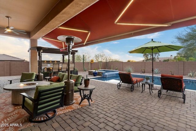 view of patio with a pool with hot tub and an outdoor fire pit