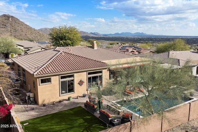 rear view of house with a mountain view and a patio area