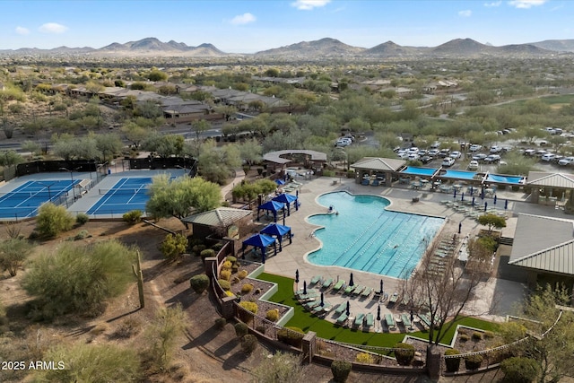 view of swimming pool with a mountain view and tennis court