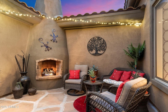 patio terrace at dusk with exterior fireplace