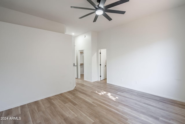 unfurnished room with ceiling fan, light hardwood / wood-style floors, and a high ceiling