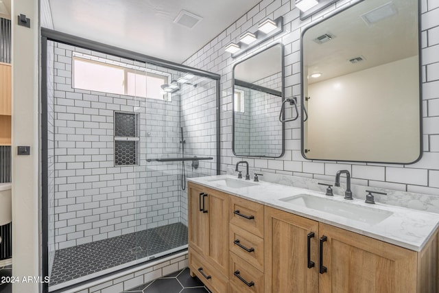 bathroom featuring vanity, tile patterned floors, decorative backsplash, tile walls, and a shower with shower door