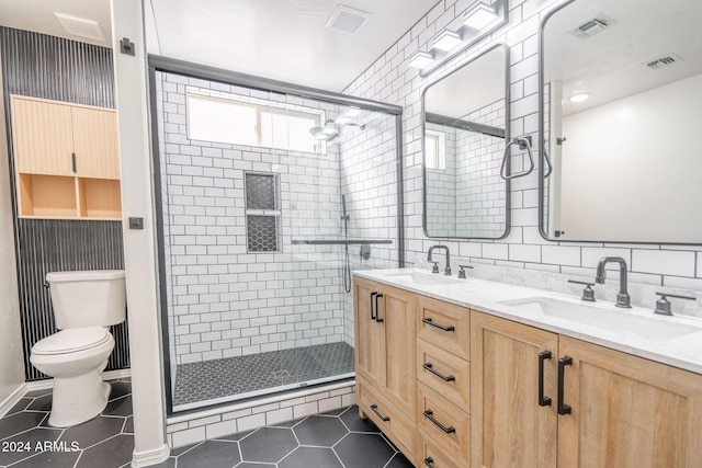 bathroom with tile patterned flooring, vanity, toilet, and walk in shower