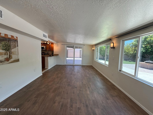 3145 W Acoma Dr, Phoenix, AZ 85053 - unfurnished living room with a textured ceiling and dark wood-style floors