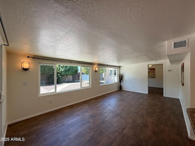 3145 W Acoma Dr, Phoenix, AZ 85053 - unfurnished living room featuring a textured ceiling, dark wood-type flooring, and plenty of natural light