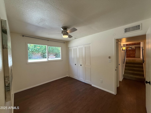 3145 W Acoma Dr, Phoenix, AZ 85053 - unfurnished bedroom with dark wood-style floors, a closet, a textured ceiling, and ceiling fan