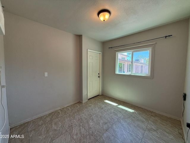 3145 W Acoma Dr, Phoenix, AZ 85053 - spare room with baseboards and a textured ceiling
