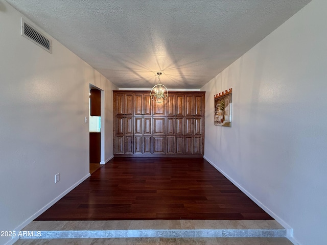 3145 W Acoma Dr, Phoenix, AZ 85053 - unfurnished dining area featuring a chandelier, dark wood-style flooring, and a textured ceiling