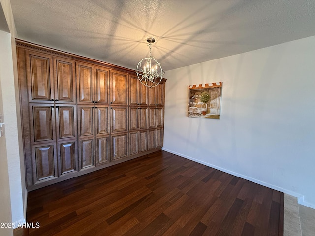 3145 W Acoma Dr, Phoenix, AZ 85053 - unfurnished dining area with dark wood-type flooring, a chandelier, and a textured ceiling