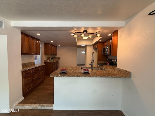 3145 W Acoma Dr, Phoenix, AZ 85053 - kitchen with stainless steel appliances, a peninsula, stone countertops, recessed lighting, and dark wood-style floors