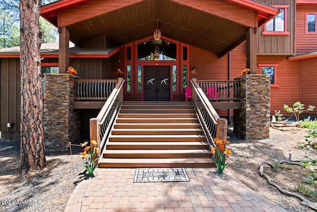 view of exterior entry featuring a porch and board and batten siding