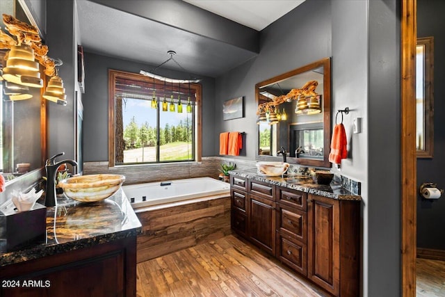 full bath with hardwood / wood-style floors, a bath, and vanity