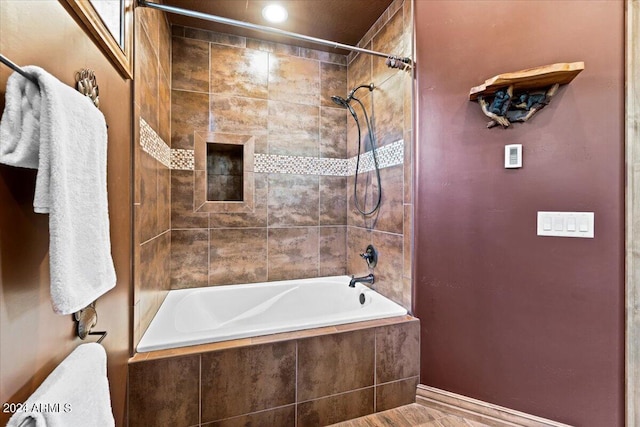 full bathroom with tiled shower / bath and baseboards