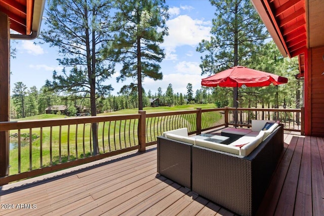 wooden terrace featuring outdoor lounge area, a yard, and view of scattered trees