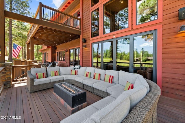 deck featuring an outdoor living space with a fire pit and french doors
