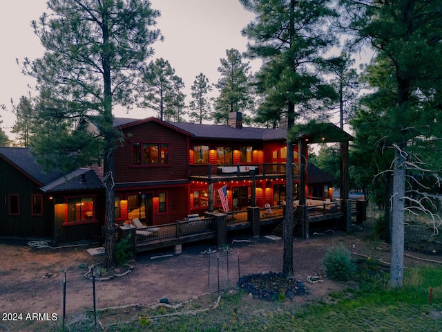 back of house with a wooden deck and a chimney