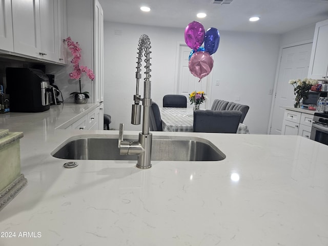 kitchen with decorative backsplash, light stone countertops, and white cabinetry