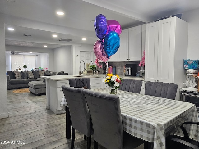 dining room with ceiling fan and sink