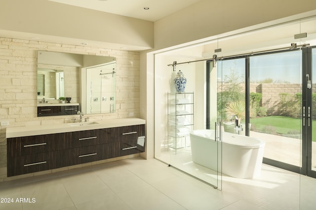 bathroom featuring tile patterned floors, vanity, and a tub to relax in