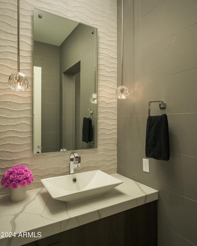 bathroom with vanity and tile walls