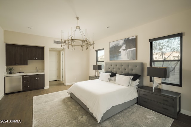 bedroom featuring a notable chandelier, dark hardwood / wood-style floors, sink, and connected bathroom