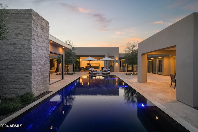 pool at dusk with a patio