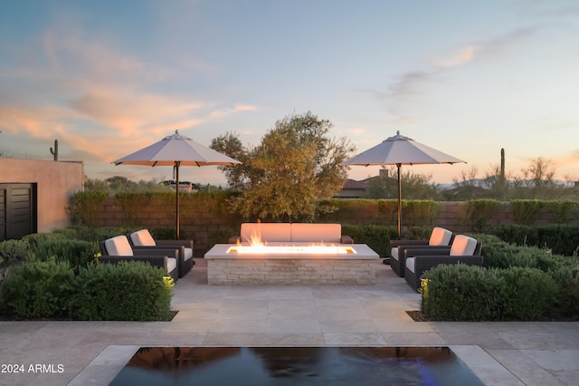 patio terrace at dusk featuring an outdoor fire pit