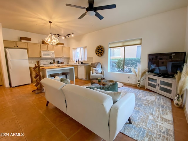 living room featuring sink, ceiling fan with notable chandelier, and light tile patterned flooring