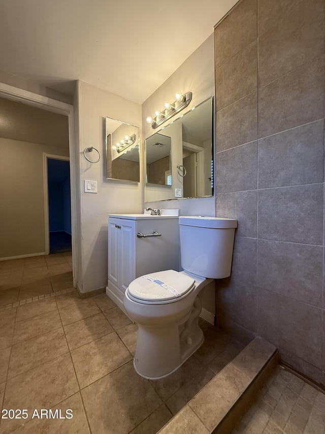 bathroom with toilet, baseboards, tile patterned flooring, and vanity