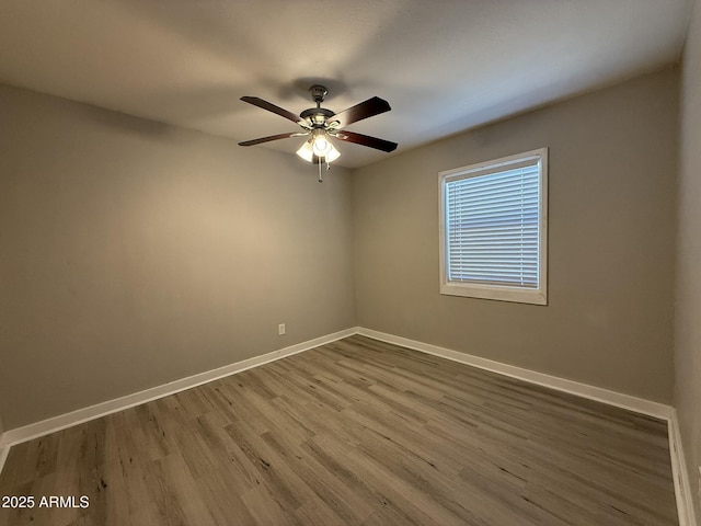 unfurnished room with wood finished floors, baseboards, and a ceiling fan