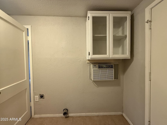 laundry area featuring baseboards, tile patterned flooring, electric dryer hookup, and laundry area