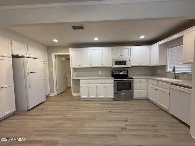 kitchen with visible vents, a sink, white appliances, recessed lighting, and white cabinetry