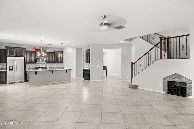 18740 W San Juan Ave, Litchfield Park, AZ 85340 - unfurnished living room with light tile patterned floors, a sink, recessed lighting, a ceiling fan, and baseboards