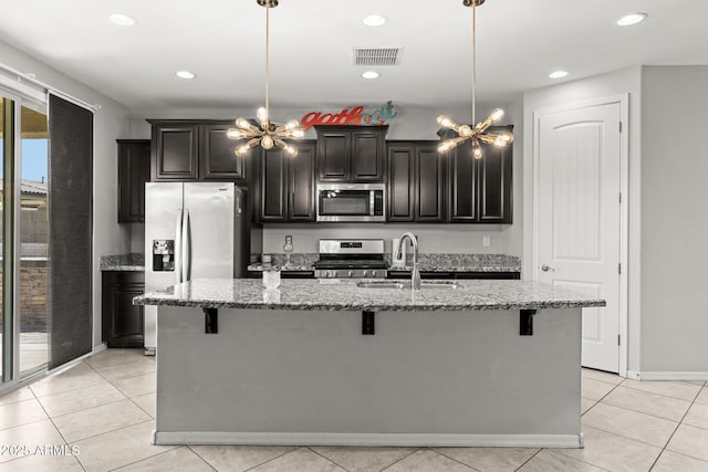18740 W San Juan Ave, Litchfield Park, AZ 85340 - kitchen with appliances with stainless steel finishes, a chandelier, a kitchen bar, a sink, and an island with sink