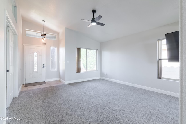 foyer with light carpet, vaulted ceiling, baseboards, and light tile patterned floors