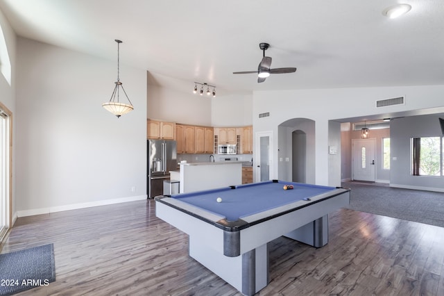 recreation room featuring arched walkways, high vaulted ceiling, dark wood-style floors, and visible vents