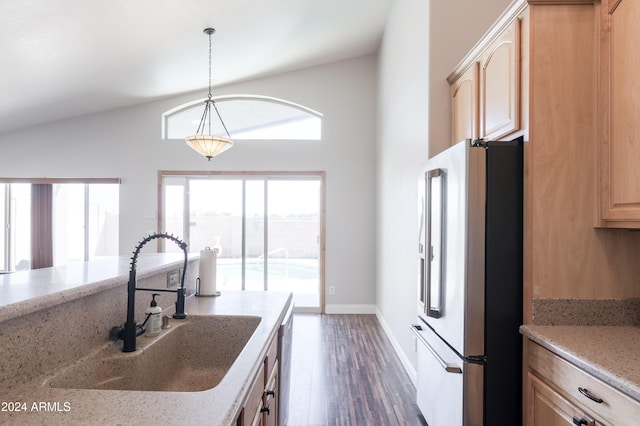 kitchen with high end refrigerator, decorative light fixtures, light brown cabinetry, a healthy amount of sunlight, and a sink