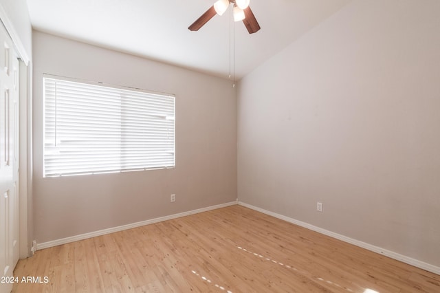 unfurnished room featuring light wood-type flooring, vaulted ceiling, ceiling fan, and baseboards