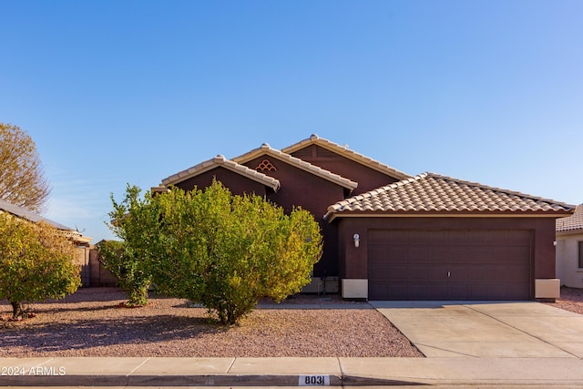 view of front of property featuring driveway, an attached garage, a tile roof, and stucco siding