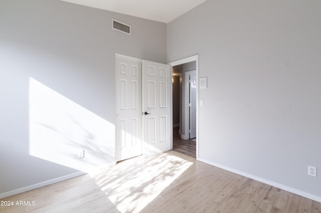 spare room featuring light wood finished floors, baseboards, and visible vents