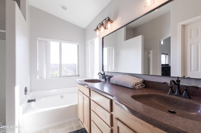 bathroom with vaulted ceiling, a garden tub, a sink, and double vanity