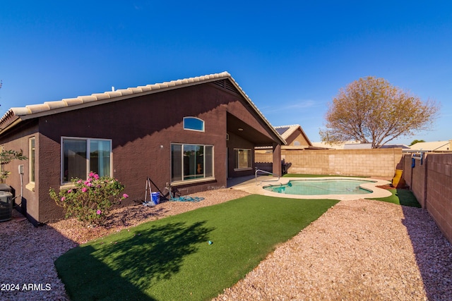 back of house featuring a fenced in pool, a patio area, a fenced backyard, and stucco siding