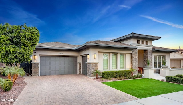 prairie-style house with a garage and a front lawn