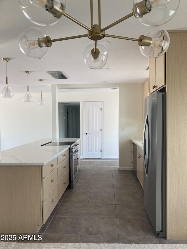 224 N 58th St, Mesa, AZ 85205 - kitchen with appliances with stainless steel finishes, light brown cabinetry, dark tile patterned flooring, and hanging light fixtures