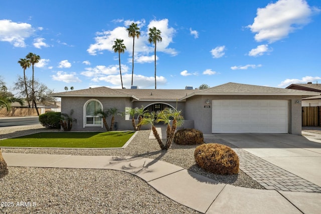 ranch-style house featuring a garage, a front lawn, concrete driveway, and stucco siding