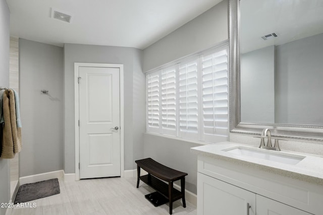 bathroom featuring baseboards, visible vents, and vanity