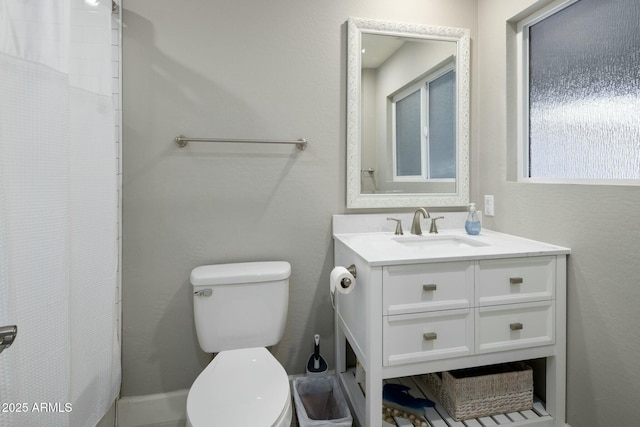 full bath with a shower with shower curtain, vanity, and toilet