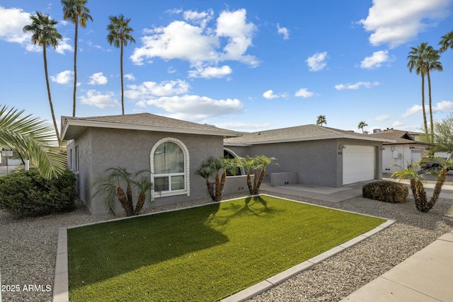 ranch-style house featuring a front lawn, a shingled roof, an attached garage, and stucco siding