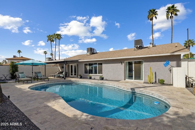 view of swimming pool with french doors, a patio area, fence private yard, and cooling unit